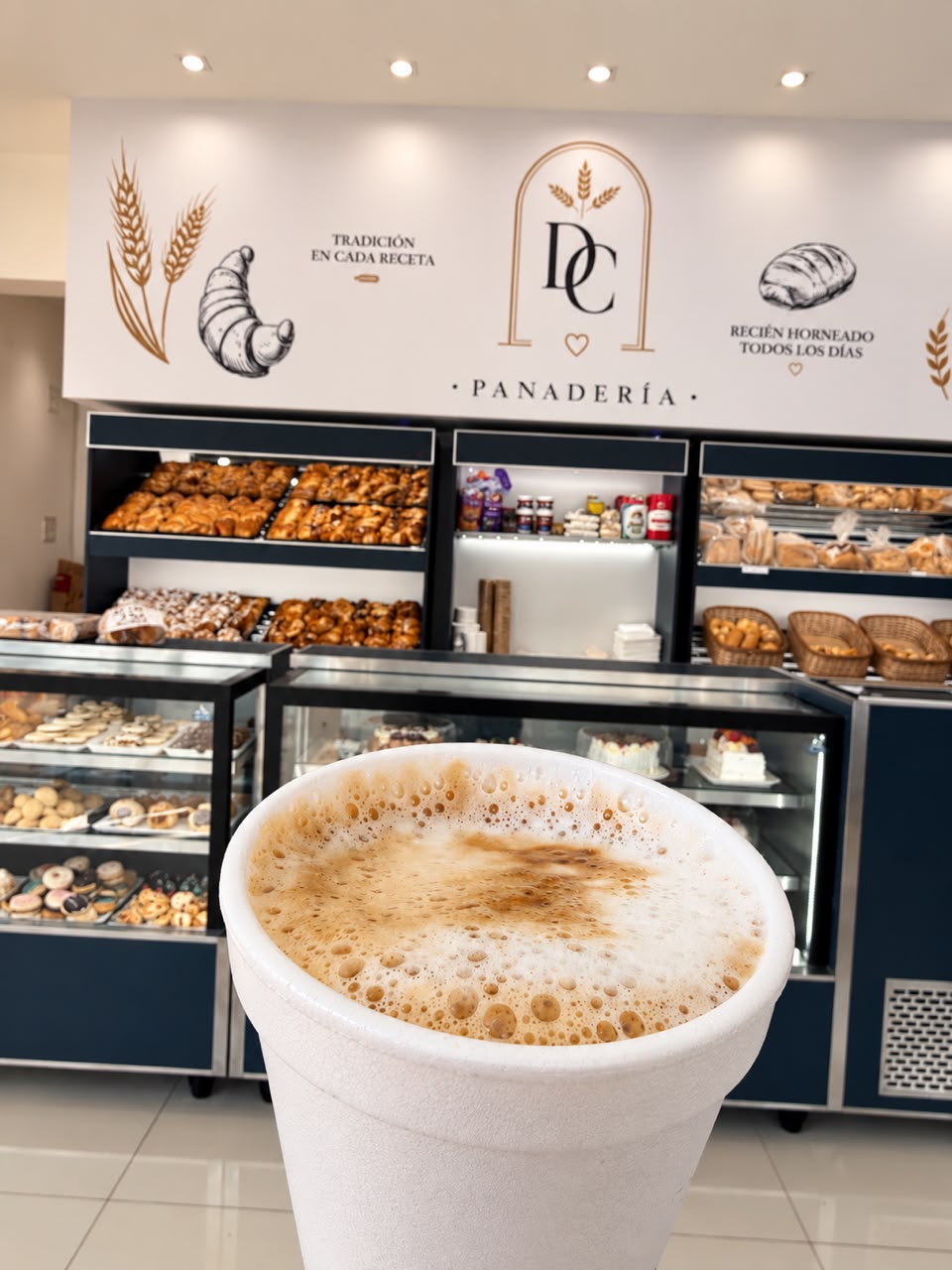 Un café en Del Castelar con el mostrador de panadería de fondo